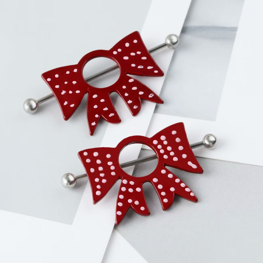 High-angle shot of two bow nipple shields styled on a decorative marble background