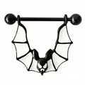 Close-up of a black bat wing nipple piercing ring with white enamel wings.
