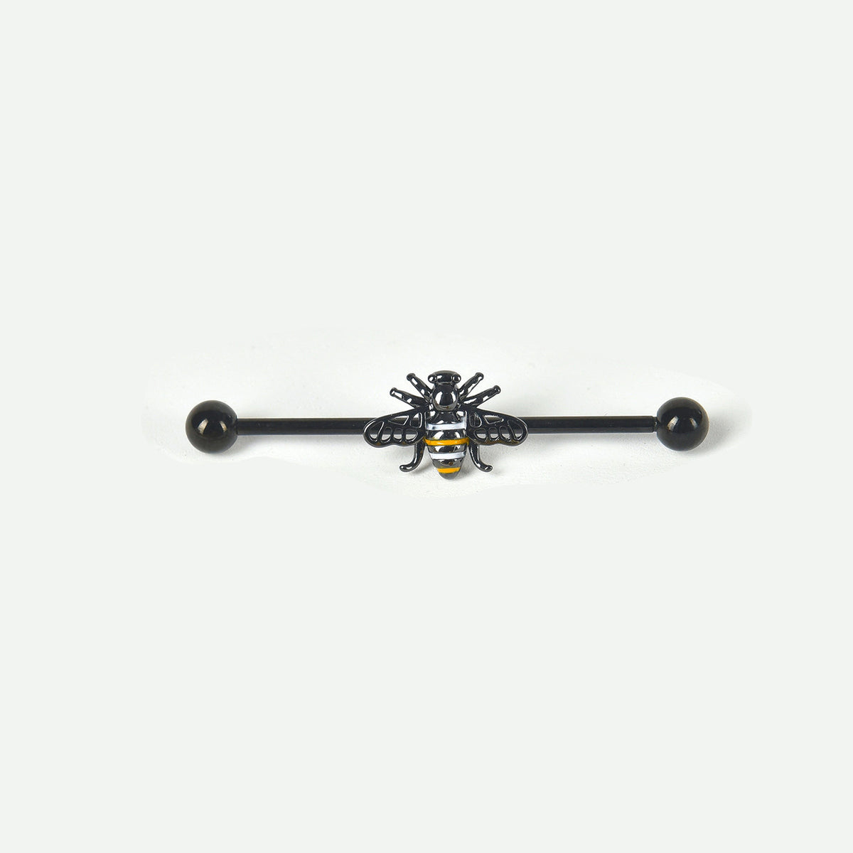 A single black industrial piercing barbell with a black and yellow striped bee charm in the center