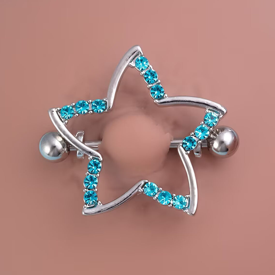 Top view of a blue crystal star nipple shield worn on a skin-tone model