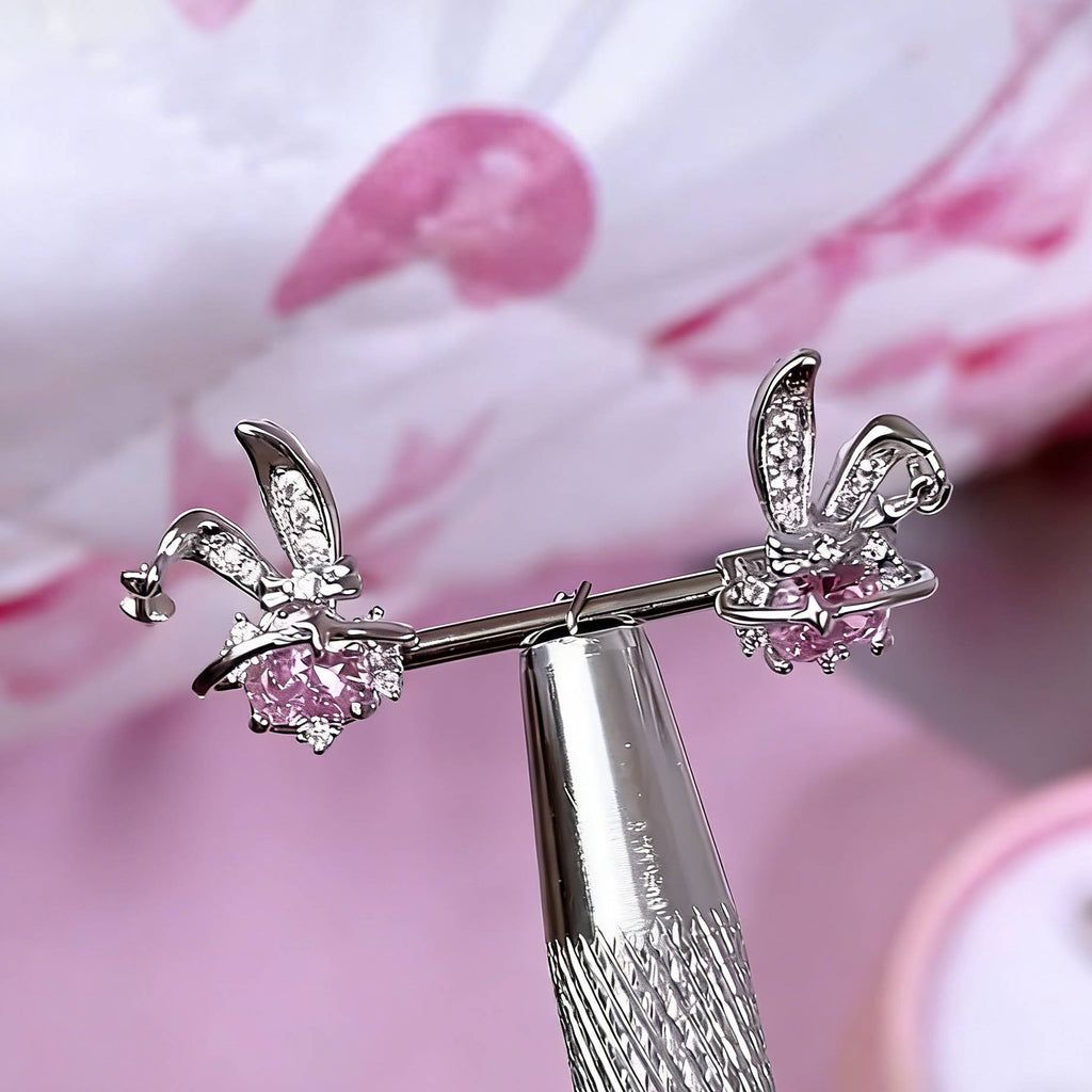 Close-up detail of a bunny-shaped nipple barbell featuring a pink heart gem and a dangling star charm.
