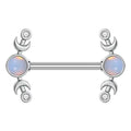 A front view of a silver-colored 14G nipple piercing barbell with dual crescent moons, clear mini crystals, and a glowing central opal stone.