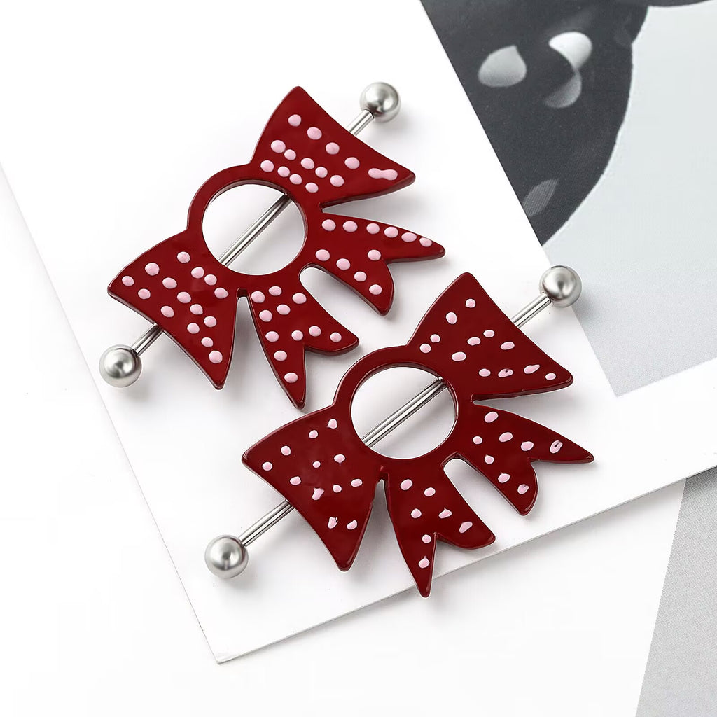 Close-up of bow-shaped nipple shields with pink dot detailing for alternative fashion