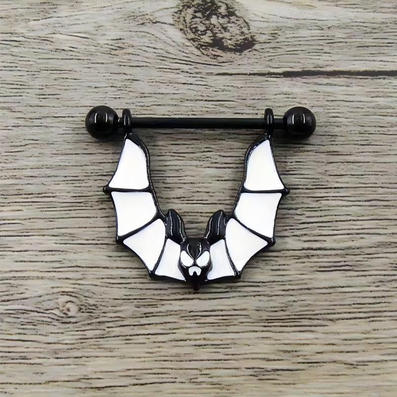 Black and white bat-shaped nipple shield on a wooden background.