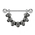 Close-up of a silver-toned nipple shield featuring seven detailed skulls in a semi-circle.