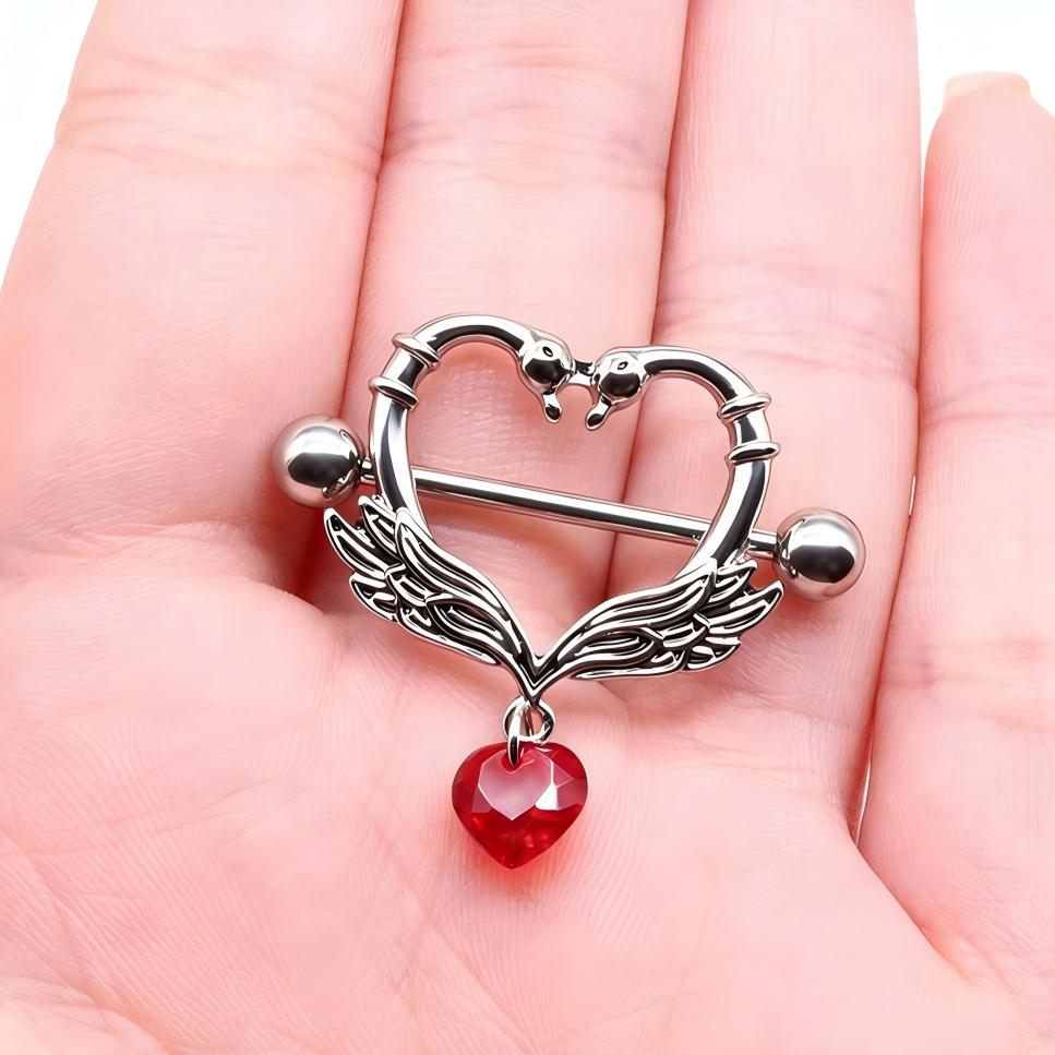 A hand holding a swan wing nipple shield to show the detailed scale and heart drop.