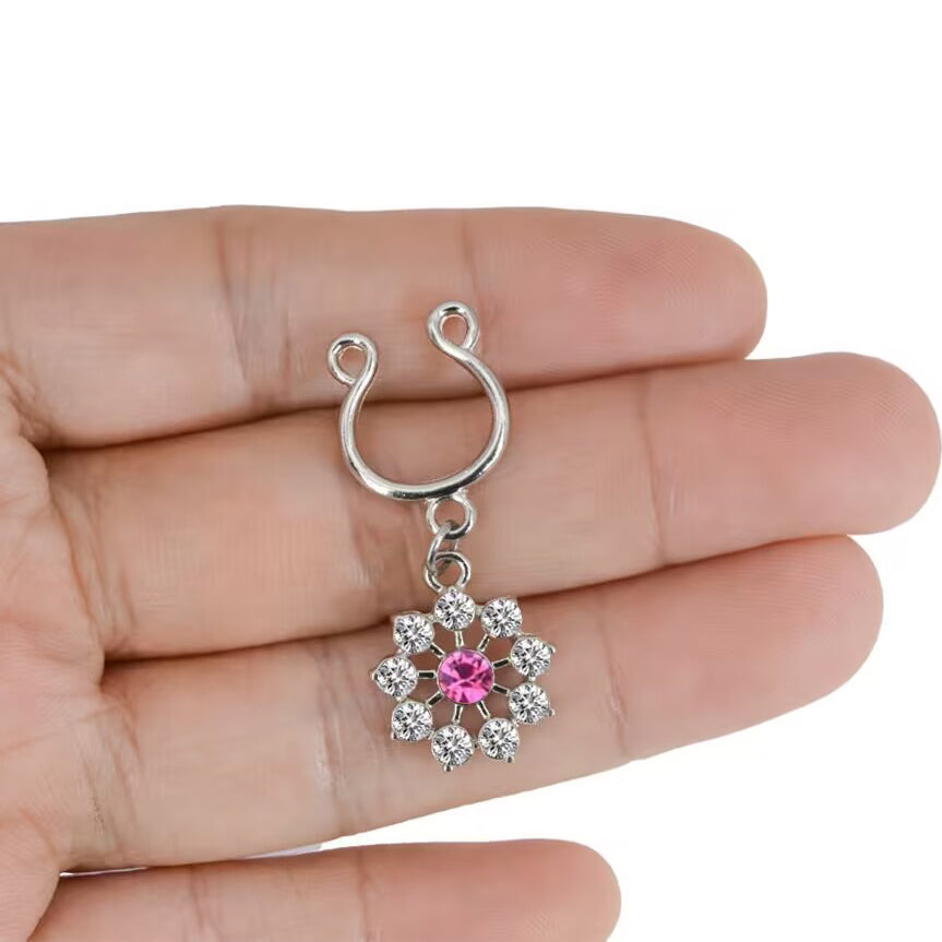 A hand holding the sparkling pink flower nipple shield to show scale and delicate craftsmanship.