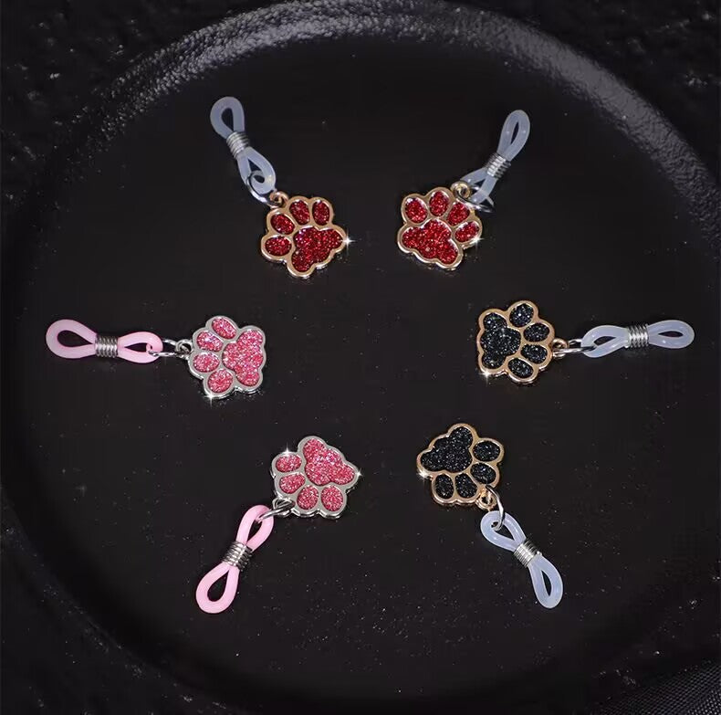 Collection of non-pierced paw print jewelry in pink, red, and black colors.