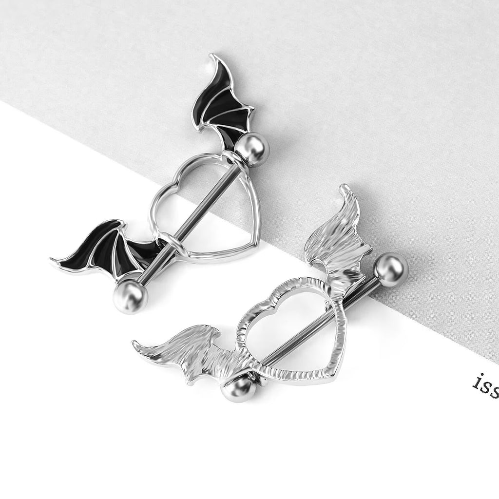 A pair of punk style bat wing heart nipple rings displayed on a clean background.