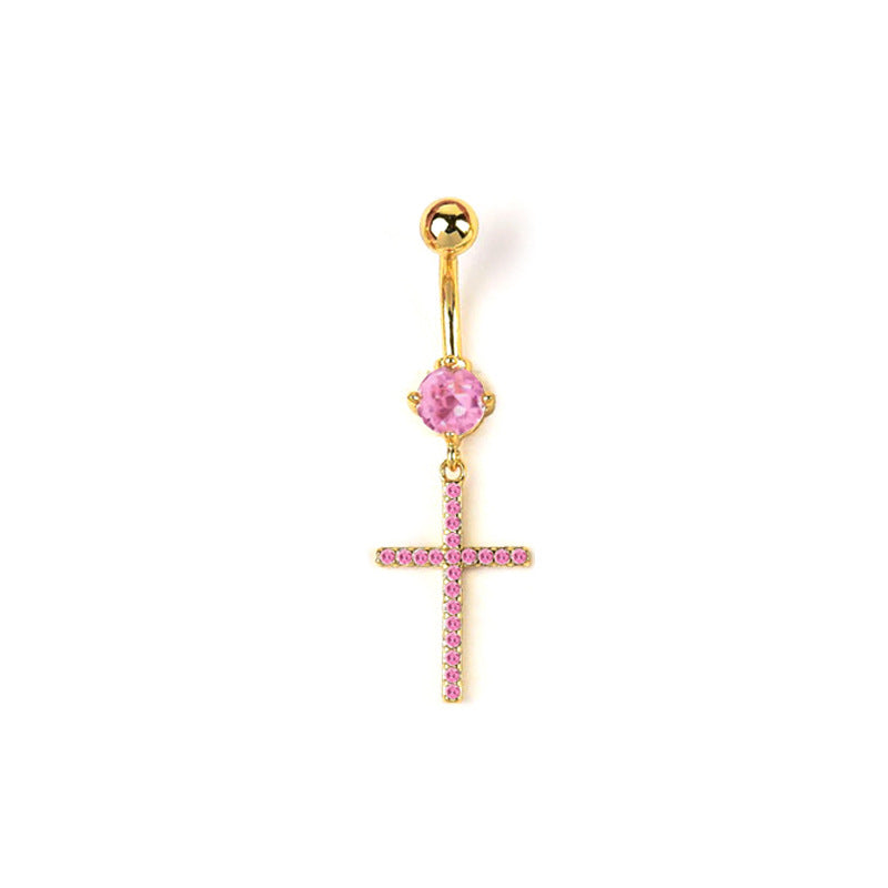A gold barbell belly button ring featuring a round pink gem and a dangling cross paved with pink crystals, isolated on a white background