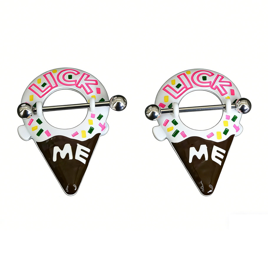 A professional studio shot of a matching pair of playful Lick Me ice cream cone nipple shields. The jewelry features white icing, a chocolate cone, colorful sprinkles, and pink 'LICK ME' text with white 'ME' text on the chocolate dip, all against a clean white background.