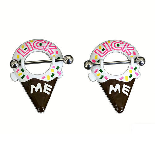 A professional studio shot of a matching pair of playful Lick Me ice cream cone nipple shields. The jewelry features white icing, a chocolate cone, colorful sprinkles, and pink 'LICK ME' text with white 'ME' text on the chocolate dip, all against a clean white background.