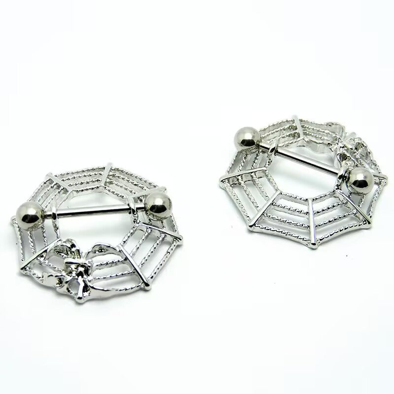 Symmetrical silver spider web nipple shields showing the web framework and barbell