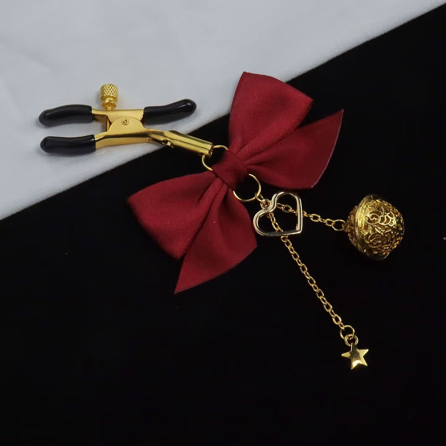 Close-up of a single red bow clamp showing the bell and heart detail.